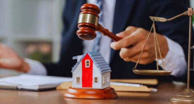 A judge's gavel is placed on a house model, with a scale model of a house in the background, emphasizing property rights in Hilton Head, SC.