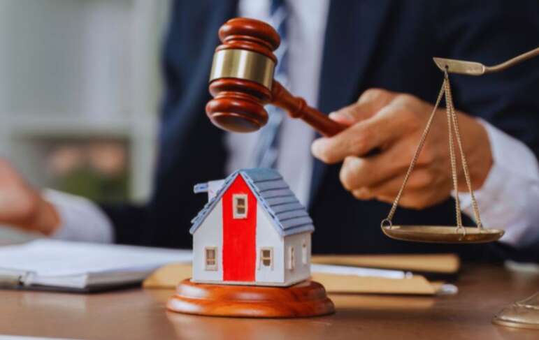 A judge's gavel is placed on a house model, with a scale model of a house in the background, emphasizing property rights in Hilton Head, SC.