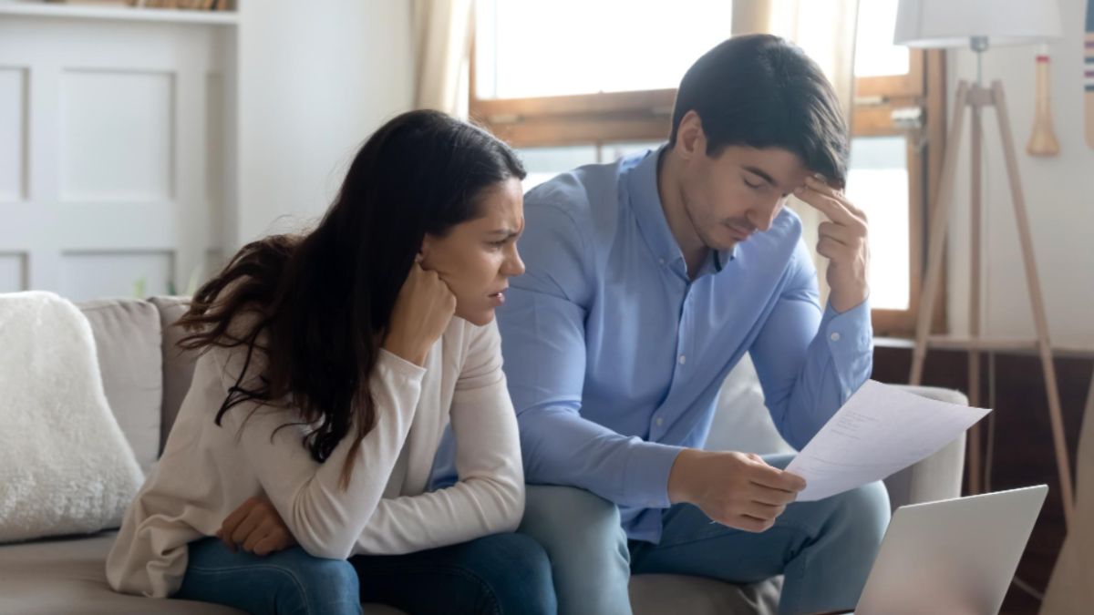 Concerned couple reviewing property dispute documents at home.