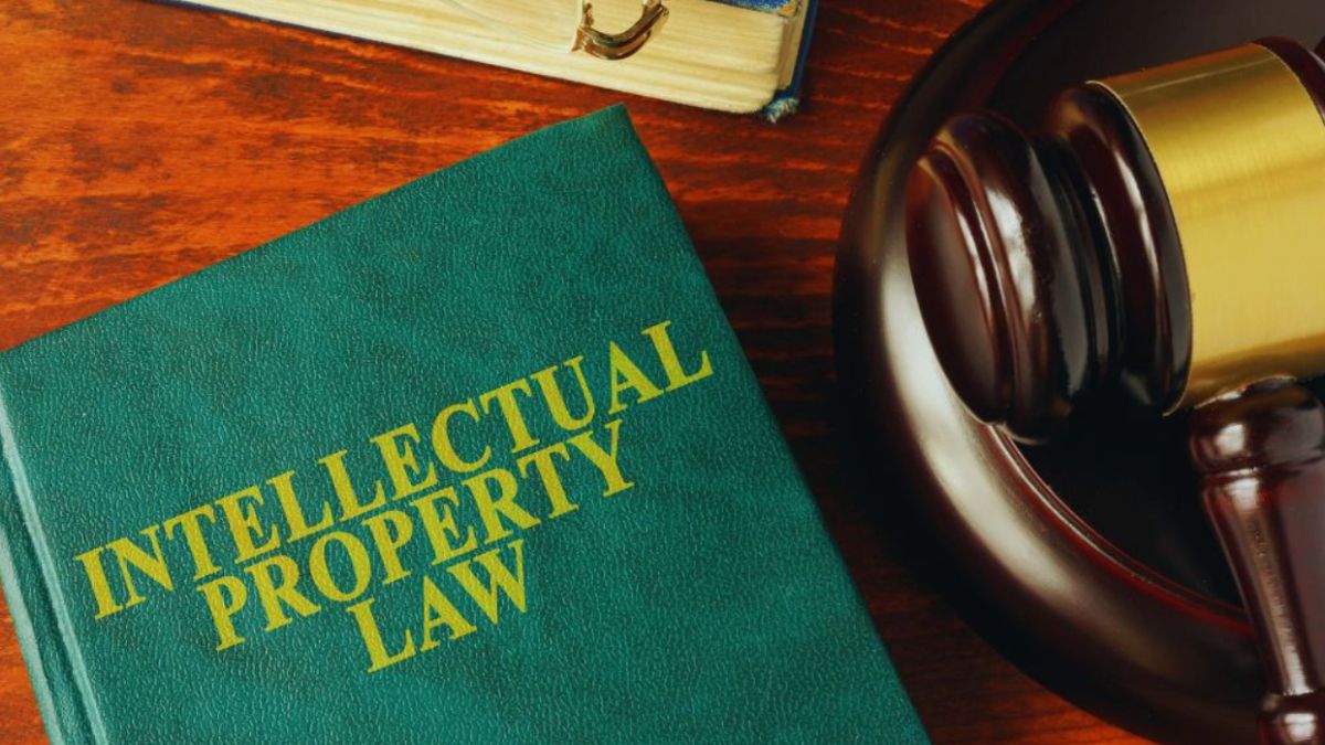Hardcover legal textbook used as a symbolic image of real property rights, placed on a wooden table beside a judge’s gavel and sound block.