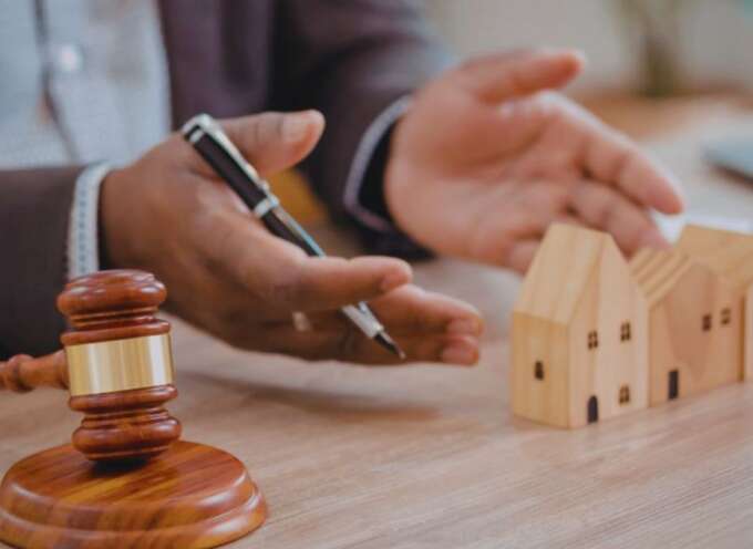 A real estate lawyer in Bluffton holds a gavel and a house model, emphasizing the legal side of real estate transactions.