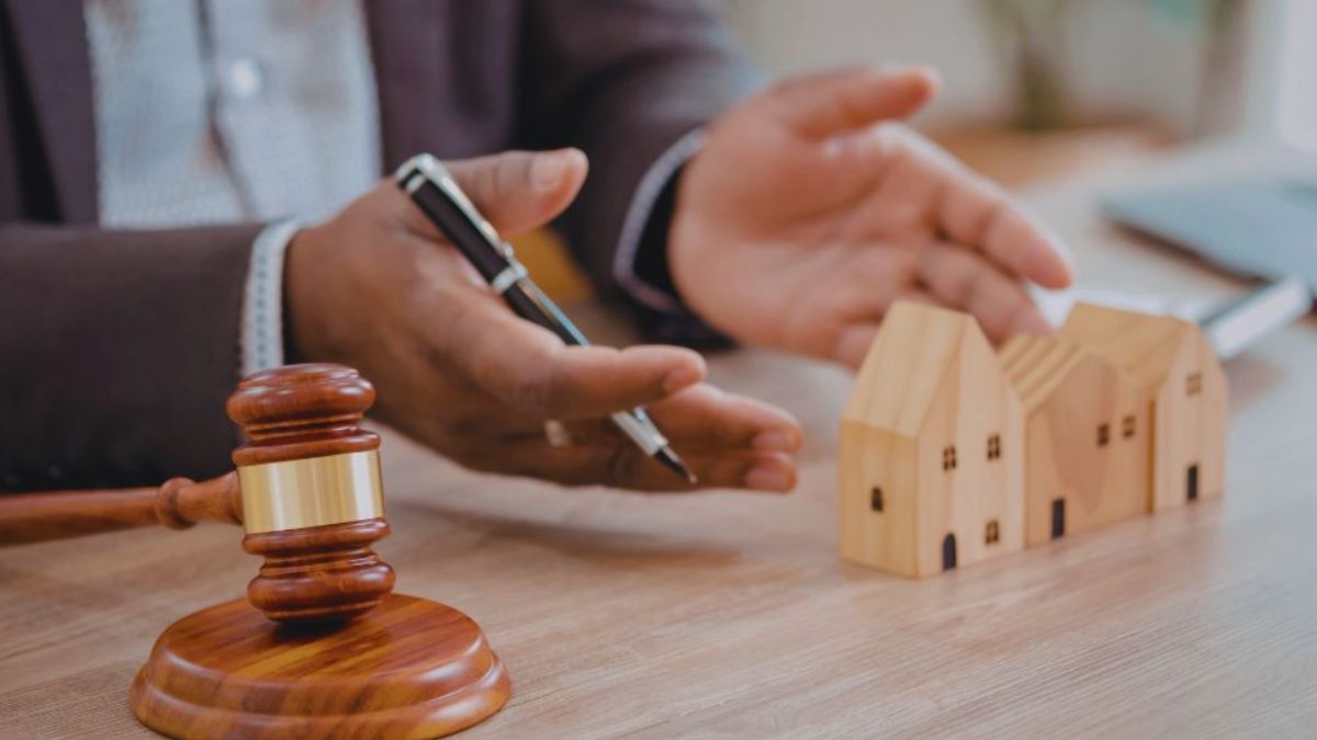 A real estate lawyer in Bluffton holds a gavel and a house model, emphasizing the legal side of real estate transactions.