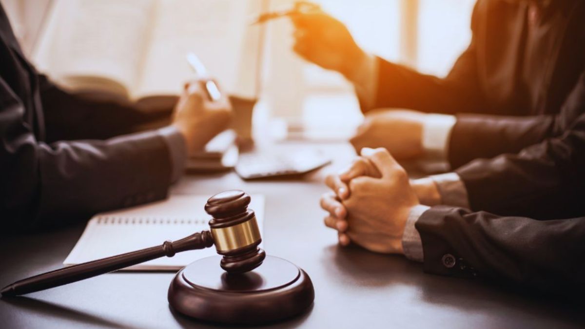 Close-up of a gavel on a desk during a meeting with a Bluffton business formation lawyer, with clients’ hands folded and legal documents open in the background.