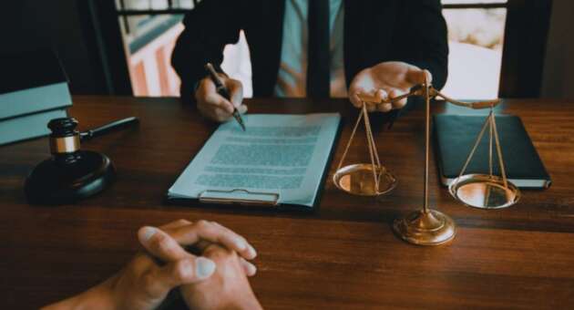 Contract law lawyer in Bluffton, SC reviewing a legal agreement with a client at a desk featuring a contract, gavel, and scales of justice.