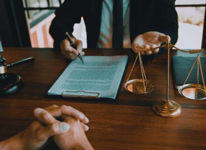 Contract law lawyer in Bluffton, SC reviewing a legal agreement with a client at a desk featuring a contract, gavel, and scales of justice.
