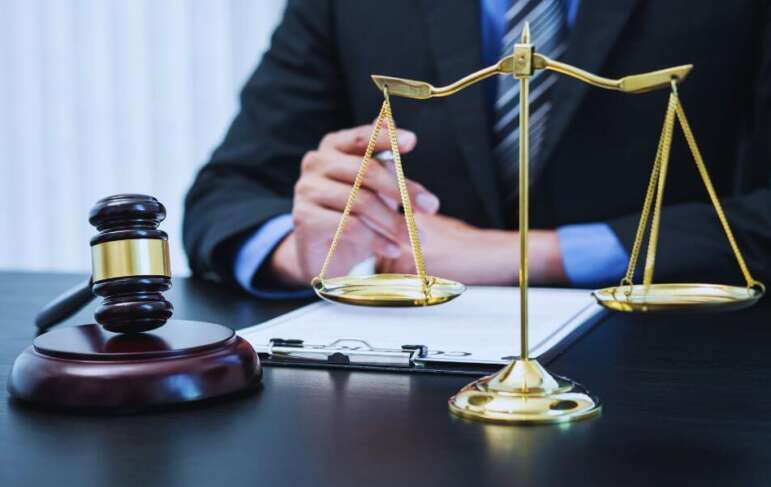 Collection lawyer seated at a desk with a gavel and scales of justice, reviewing documents related to debt collection and legal enforcement.