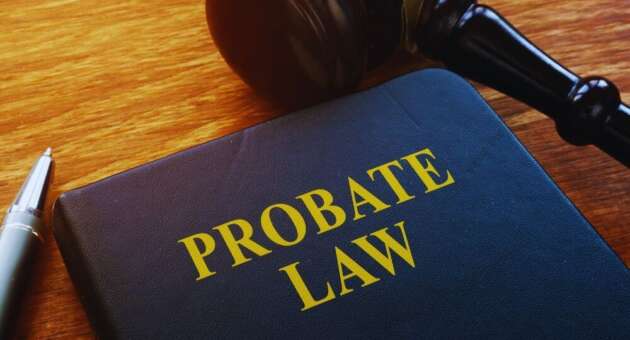 Leather-bound book titled “Probate Law” next to a judge’s gavel and pen on a wooden desk, illustrating probate lawyer and estate administration concepts.