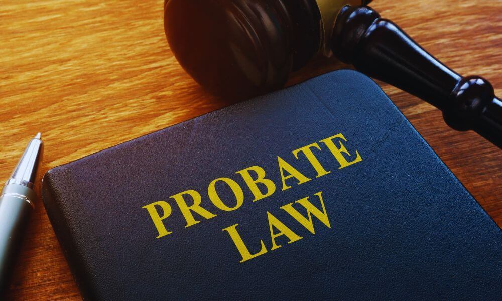 Leather-bound book titled “Probate Law” next to a judge’s gavel and pen on a wooden desk, illustrating probate lawyer and estate administration concepts.
