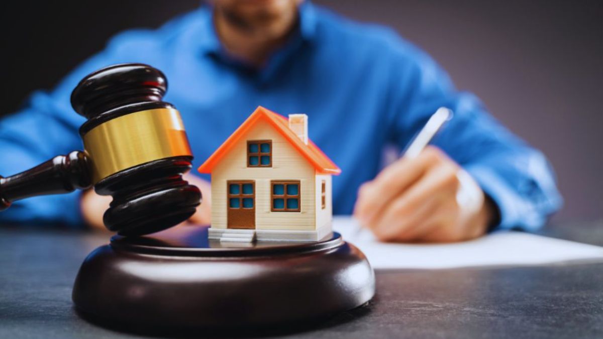 Property dispute attorney in South Carolina writing at a desk with a judge’s gavel and a small model house in the foreground, symbolizing legal help for real estate conflicts.