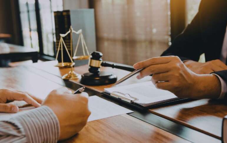 Contract lawyer reviewing legal documents with a client at a desk in a Hilton Head office.