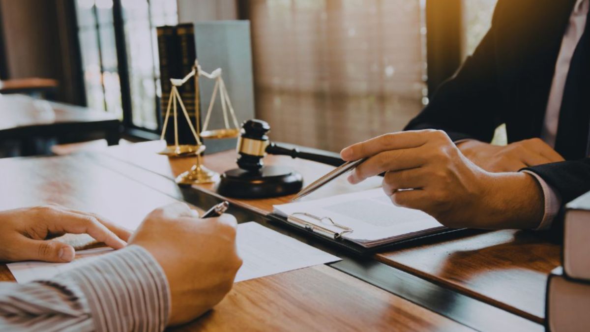 Contract lawyer reviewing legal documents with a client at a desk in a Hilton Head office.