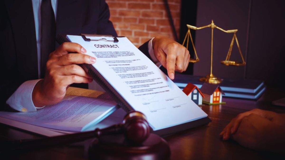 Contract lawyer explaining a contract to a client at a desk in a Hilton Head law office.