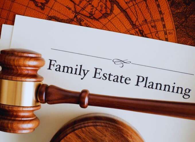 Wooden judge’s gavel resting on a legal document titled ‘Family Estate Planning’ against a vintage world map background, representing legal guidance for family estate planning.