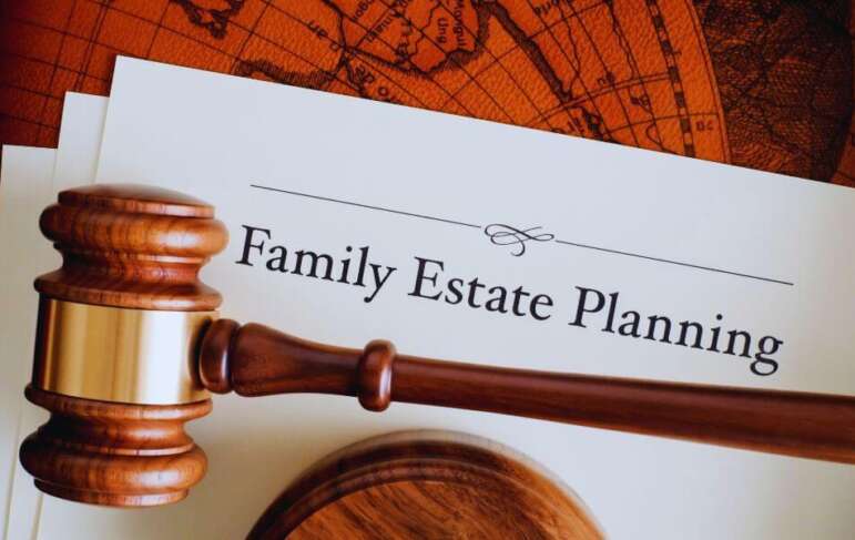 Wooden judge’s gavel resting on a legal document titled ‘Family Estate Planning’ against a vintage world map background, representing legal guidance for family estate planning.