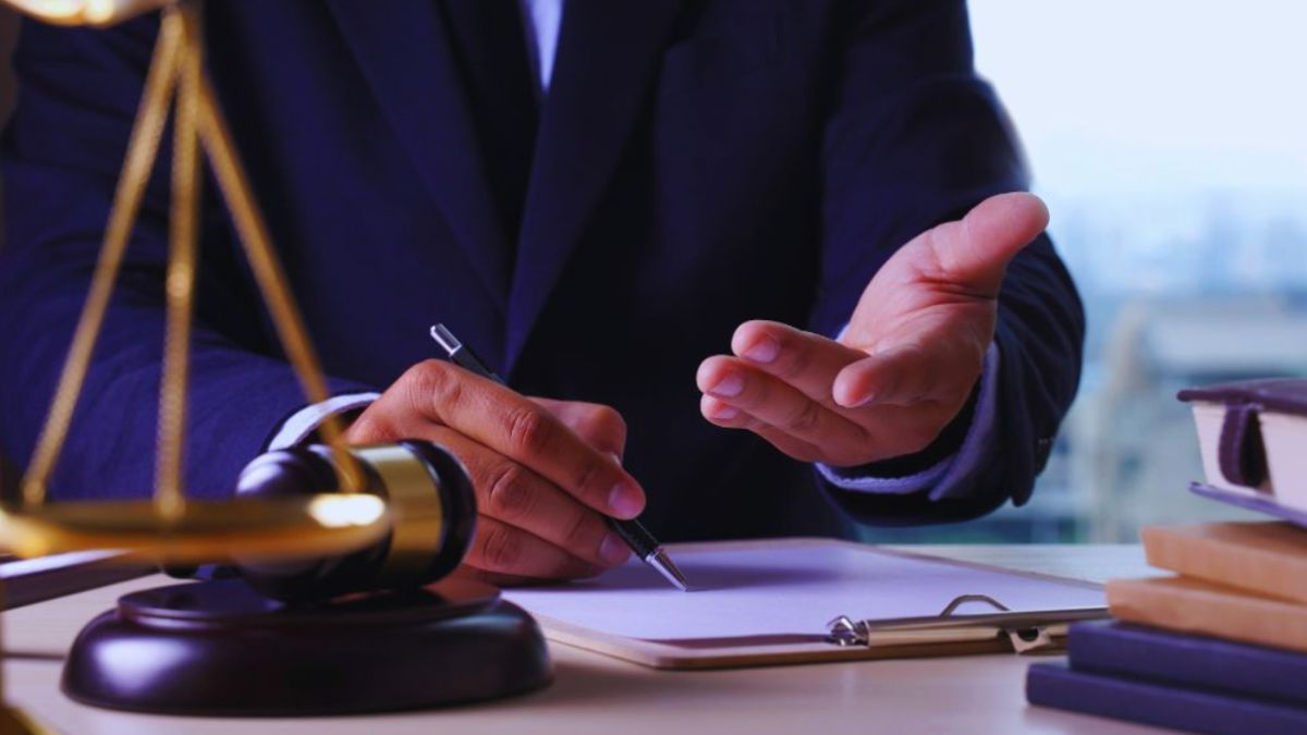 Debt collection attorney in Hilton Head reviewing legal documents and explaining debt recovery options, with a gavel, scales of justice, and law books on the desk.