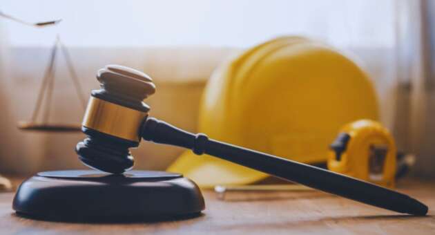 Judge's gavel with a construction hard hat and measuring tape in the background, representing legal services from a Bluffton construction accident lawyer for injured workers.