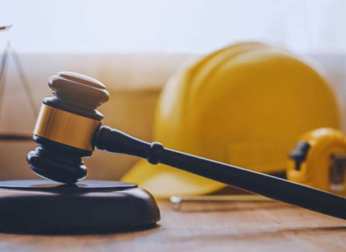 Judge's gavel with a construction hard hat and measuring tape in the background, representing legal services from a Bluffton construction accident lawyer for injured workers.