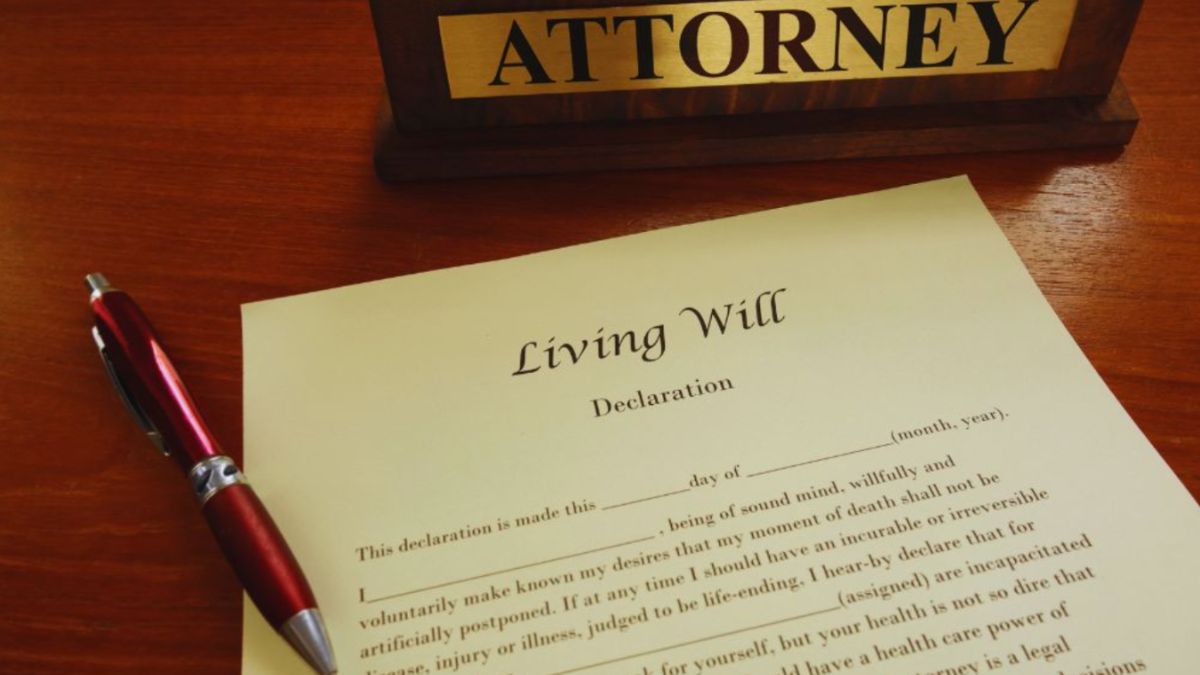 Living declaration document beside an attorney nameplate and red pen on a wooden desk in South Carolina.