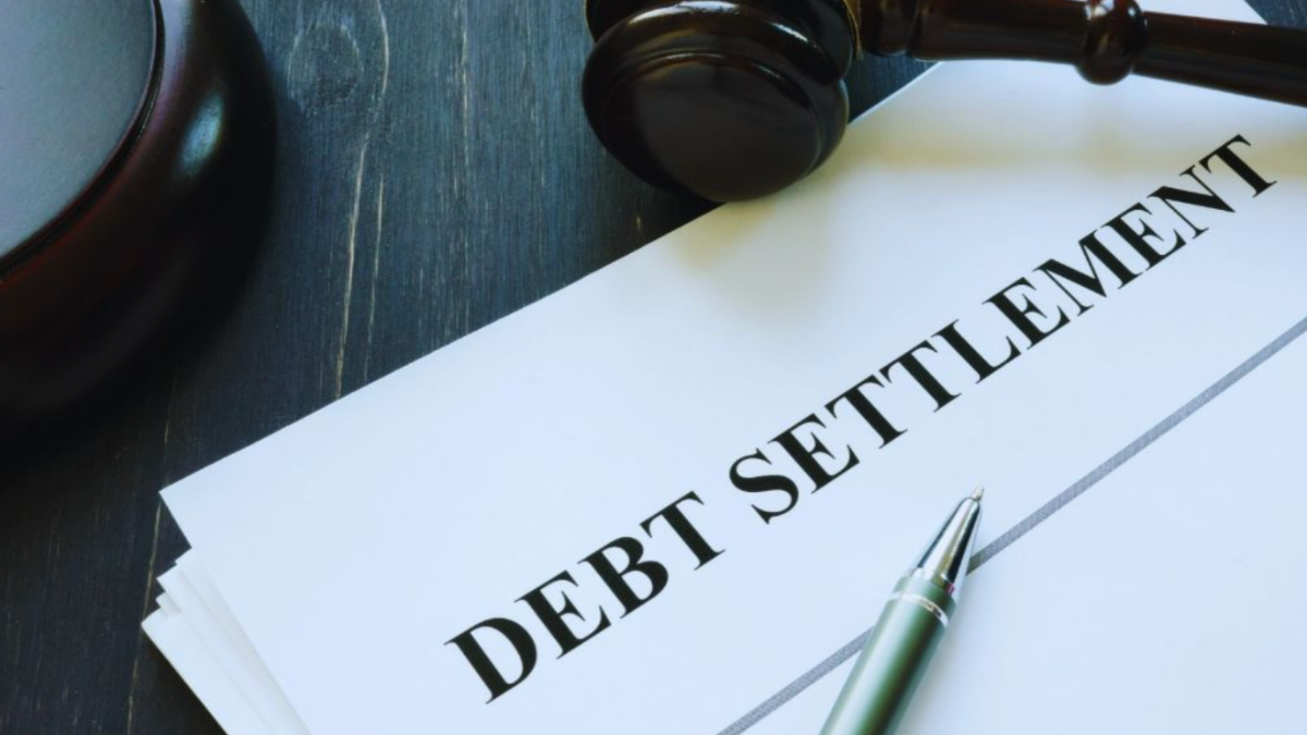 Debt settlement document with a gavel and pen on a desk.
