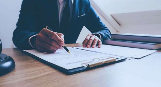 Construction litigation attorney in Hilton Head, SC, reviewing and signing legal documents at a desk.