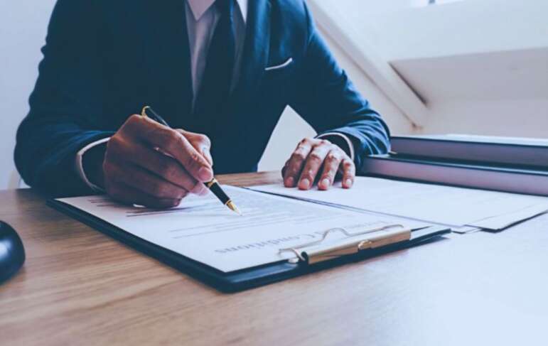 Construction litigation attorney in Hilton Head, SC, reviewing and signing legal documents at a desk.